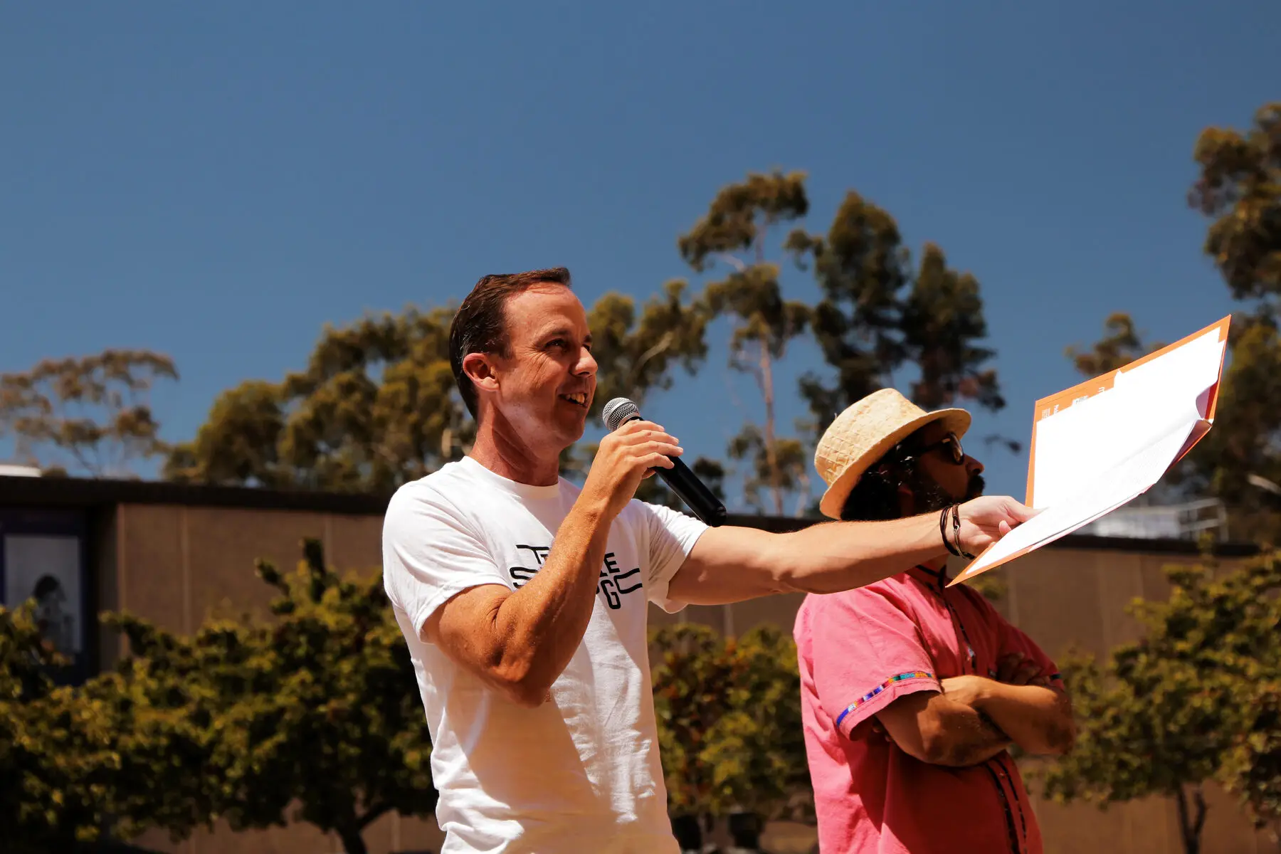 A man with a microphone presents a map outdoors