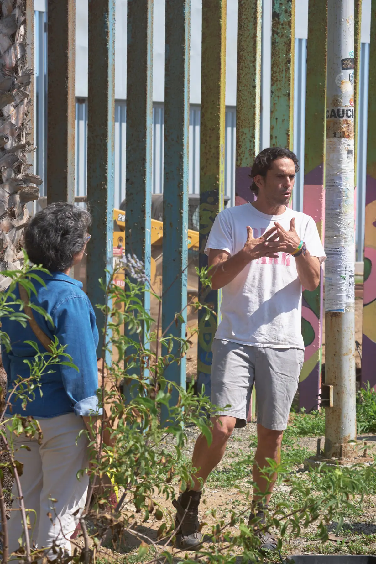 A guide speaks with visitors beside the border fence
