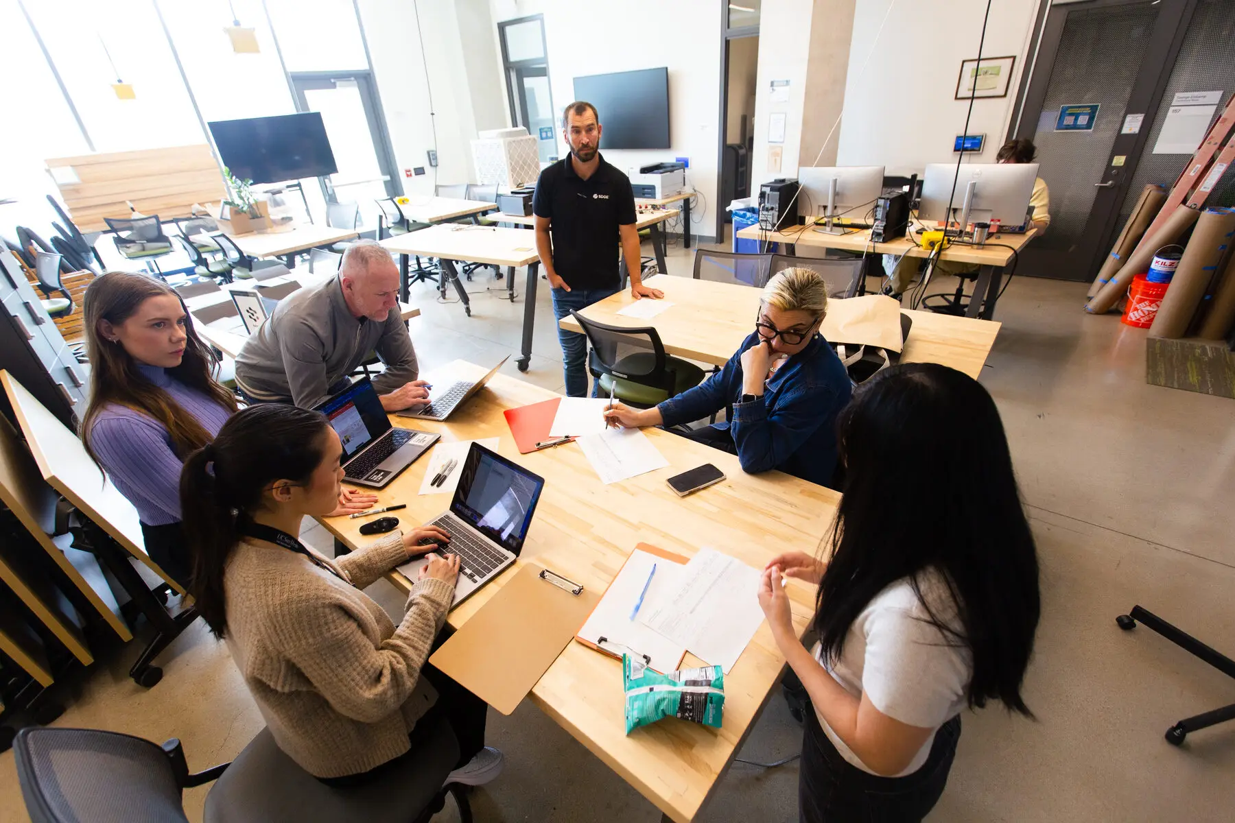 Students work at long tables in the Design Lab